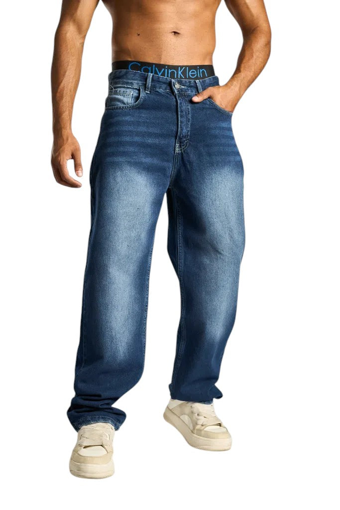 My Store baggy fit dark blue denim jeans worn by a muscular man with white sneakers