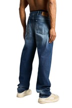 My Store baggy fit dark blue denim jeans worn by a shirtless man, back view showing pockets and leather patch