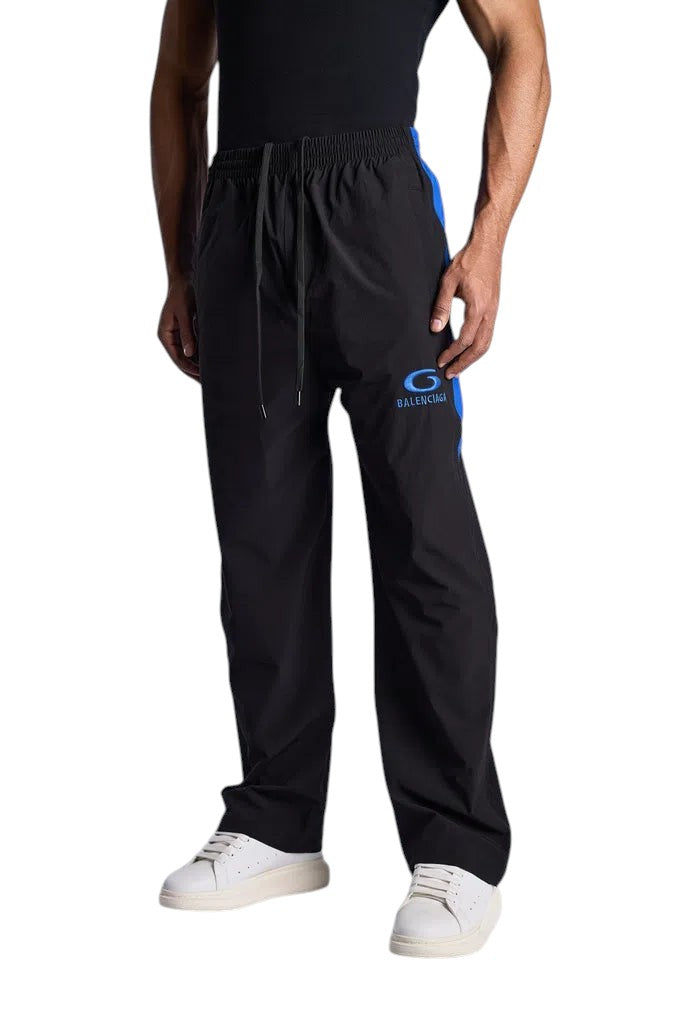 My Store BALENCIAGA black tracksuit pants with blue side stripes and logo detail worn by a model