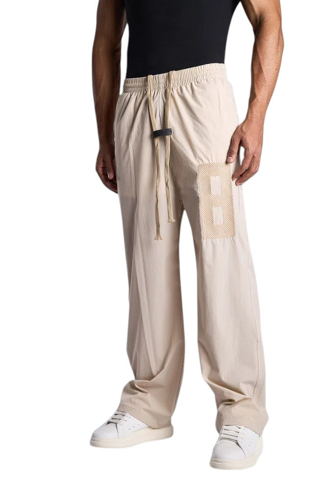 My Store ESSENTIALS beige track pants with an elastic drawstring waist and a textured patch detail on the leg