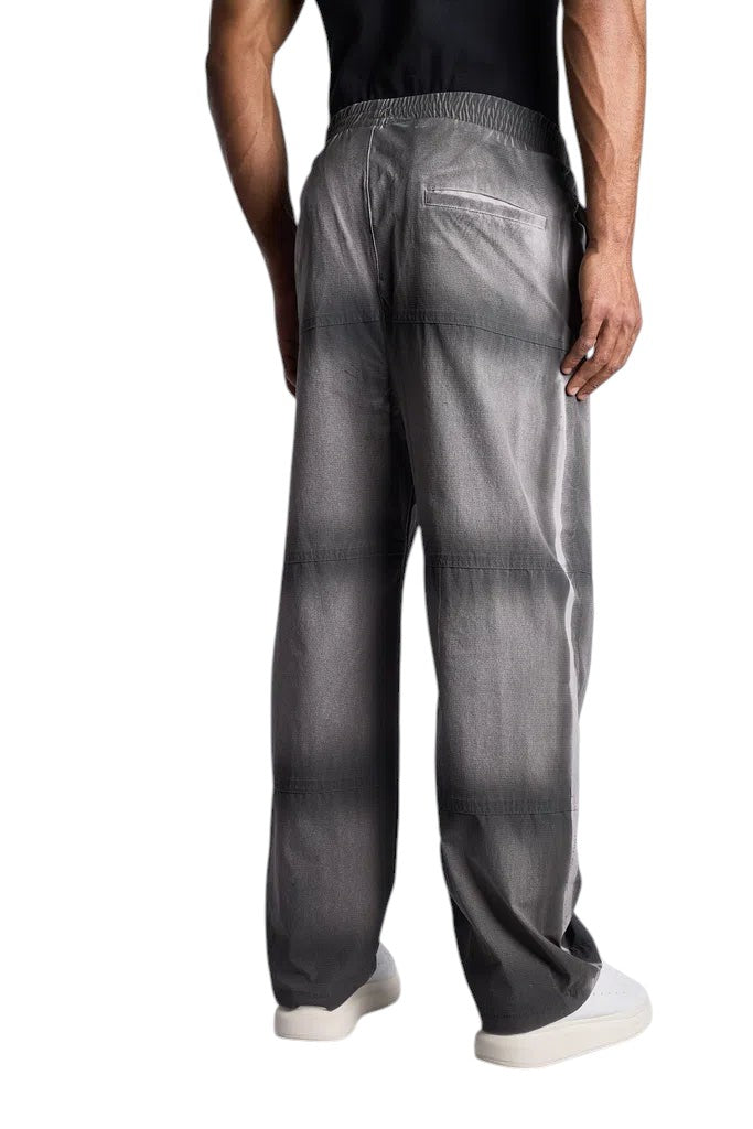 Back view of a man wearing My Store Represent sweatpants in a grey washed gradient finish with an elastic waistband.