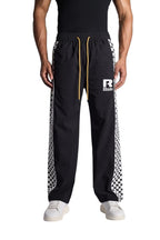 My Store Rhude black track pants with white checkered side stripes, elastic waist, and yellow drawstring
