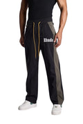 My Store Rhude black and green Aerial track pants with white logo and yellow drawstring worn by a male model