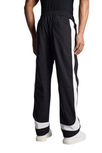 My Store Rhude black and off-white ski track pants with side stripes worn by a model, back view