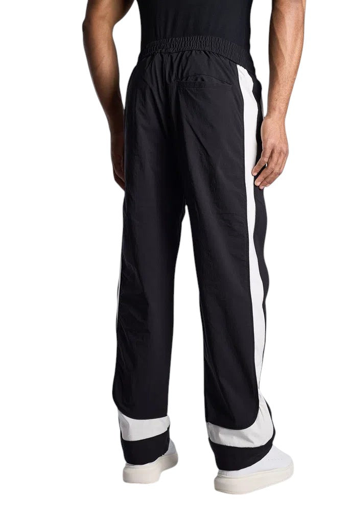 My Store Rhude black and off-white ski track pants with side stripes worn by a model, back view