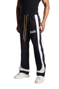 My Store Rhude black and off-white track pants with side stripes and yellow drawstring worn by a model