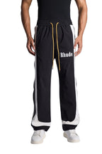My Store Rhude black and off-white ski track pants with yellow drawstring and white logo detail on a model