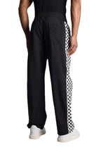 My Store Rhude track pants in black with a white and black checkered side stripe worn by a man from the back view