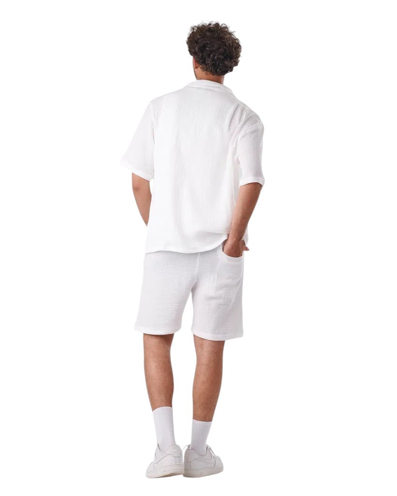 Back view of a man wearing a My Store white linen short set with a textured button-down shirt and matching shorts.