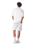 Back view of a man wearing a My Store white linen short set with a textured button-down shirt and matching shorts.