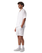 My Store white linen short set worn by a man in profile view with white sneakers