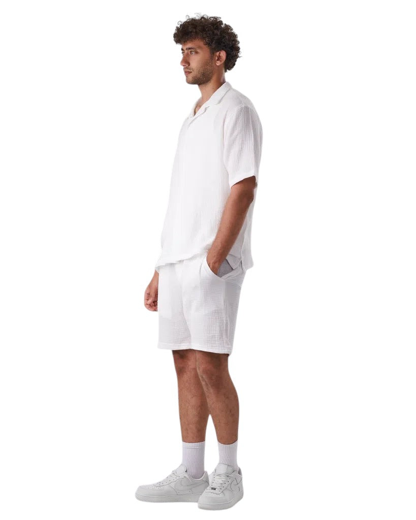 My Store white linen short set worn by a man in profile view with white sneakers
