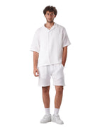 My Store white linen short set featuring a short-sleeved button-down shirt and matching shorts on a male model