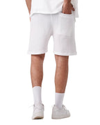 Back view of a man wearing white My Store linen shorts with a textured fabric and a back pocket