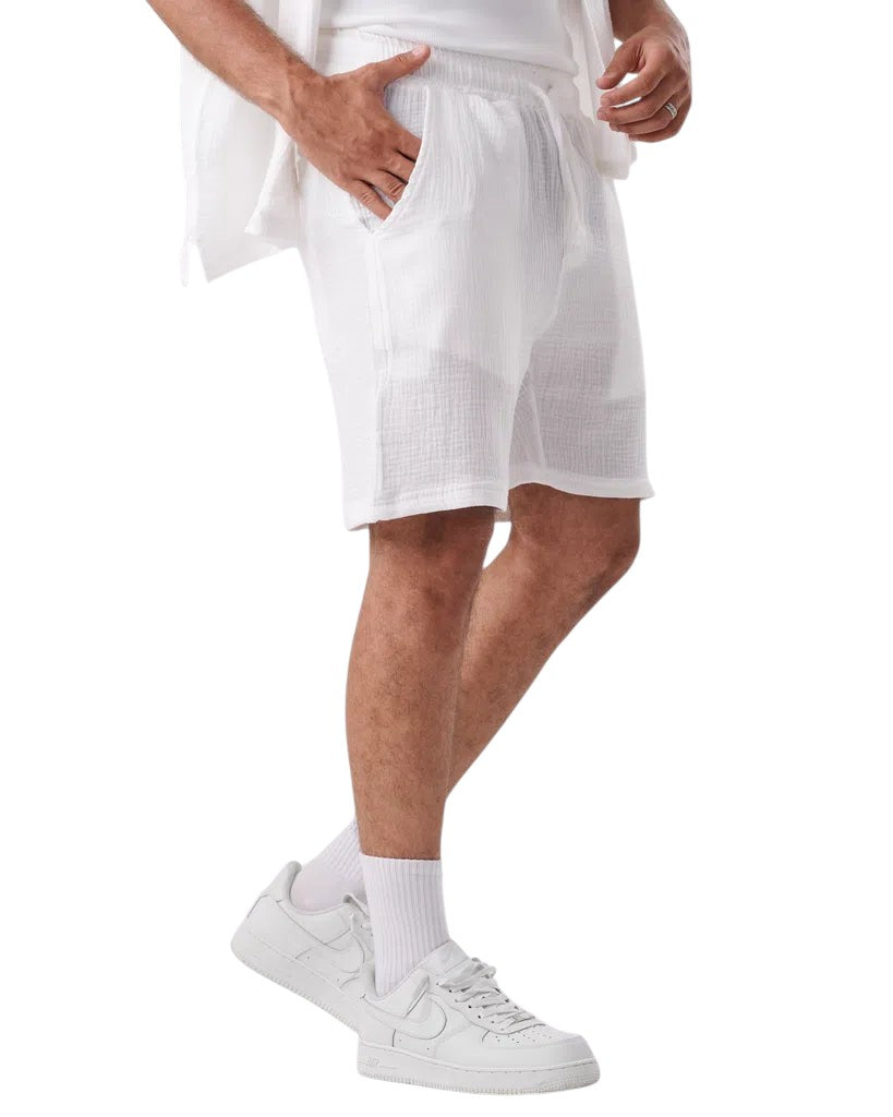 My Store white linen shorts with an elastic waistband worn by a man with white sneakers